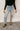front view of model wearing the Rooted Denim: Mila Light Wash Distressed Jeans that have light wash denim fabric, two front pockets, two back pockets, a front zipper, belt loops, distressing and frayed hems.
