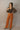 Full body front view of model wearing the Lexie Camel Wide Leg Pants that have camel lightweight fabric, a seam down each front leg, a slight v waistline, a back zipper closure, and wide legs.