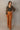 Full body front view of model wearing the Lexie Camel Wide Leg Pants that have camel lightweight fabric, a seam down each front leg, a slight v waistline, a back zipper closure, and wide legs.
