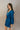 Side view of model wearing the Lottie Blue Satin Long Sleeve Mini Dress that has deep blue satin fabric, mini length, a v-neck, and long balloon sleeves.