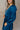 Close Side view of model wearing the Lottie Blue Satin Long Sleeve Mini Dress that has deep blue satin fabric, mini length, a v-neck, and long balloon sleeves.