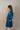Side view of model wearing the Lottie Blue Satin Long Sleeve Mini Dress that has deep blue satin fabric, mini length, a v-neck, and long balloon sleeves.