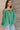 Front side view of model wearing the Audrey Green Satin Adjustable Neckline Long Sleeve Top which features green satin fabric, a round neckline with a drawstring tie, and long balloon sleeves with elastic wrists.