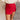 Front view of model wearing the Ruby Red Slit Detail Mini Skort which features red lightweight fabric, slit on the side, red shorts lining, mini length and monochromatic back zipper with hook closure.