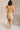 Full body back view of model wearing the Amber Gold Cowl Neckline Sleeveless Mini Dress which features gold shimmer fabric, mini length, gold lining, a cowl neckline, adjustable straps, and a monochromatic back zipper with a hook closure.
