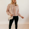 Full body front view of model wearing the Ada Blush Waffle-Knit Long Sleeve Top that has light pink textured fabric, a raw hem, a round neckline, dropped shoulders, and long sleeves with cuffs.