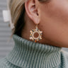Side view of model wearing the Emma Multi Sunburst Open Circle Earring which features dangle circles with rectangle shaped multi stones and circular clear stones.