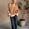 Full body front view of model wearing the Lucia Camel & Cream Collared Sweater that hascamel knit fabric with a cream color block pattern, a collared neckline and long sleeves.