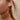 Close up view of model wearing the Thea Black & Gold Skeleton Dangle Earring which features three black and gold skeleton heads linked together.