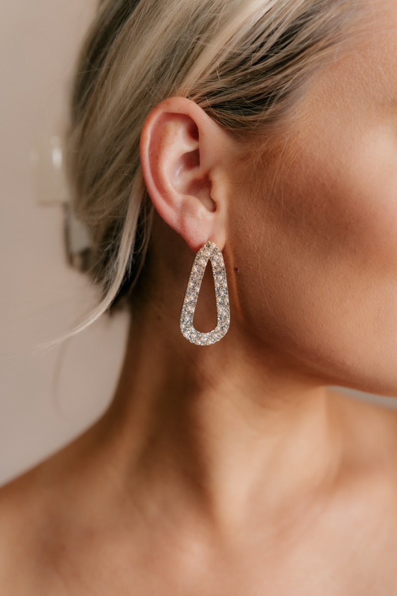 Close up view of model wearing the Jenna Rhinestone & Pearl Beaded Earring which features teardrop shaped filled with pearls and clear rhinestone design, set in gold.