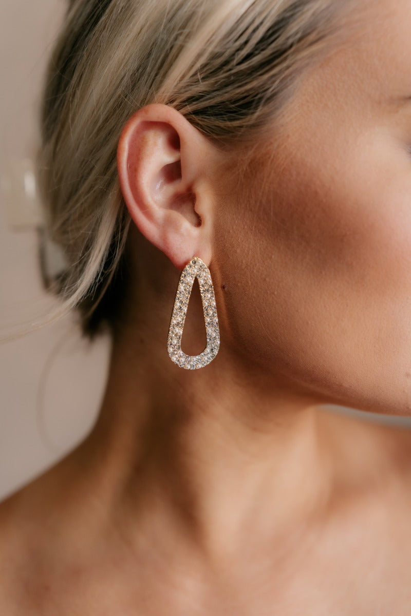 Close up view of model wearing the Jenna Rhinestone & Pearl Beaded Earring which features teardrop shaped filled with pearls and clear rhinestone design, set in gold.
