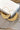 Close-up image of the Flying Free Earrings, which have gold wire hoops with gold metal feathers at the bottom.