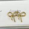 Close-up view of the 'everyday' gold bow earrings.