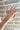 Close-up image of model's hand; model is wearing the Full Bloom Ring Set, which includes 5 varied gold rings. Rings are shown on two different fingers.