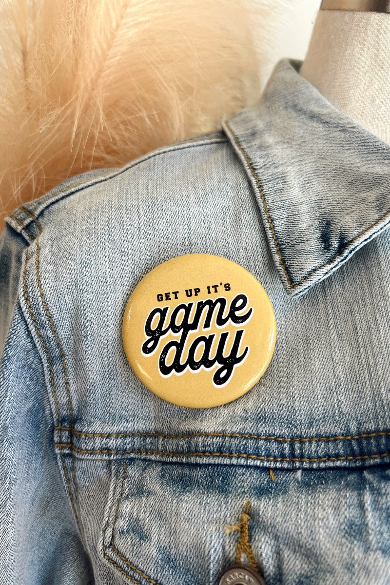 Close up image of the Get Up It's Gameday Button which features a yellow button with black text that says "Get up it's game day".