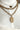The Dare To Be Necklace features a triple layer chain link with gold hammered medallions.
