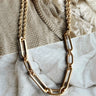 Flat lay of the Always Together Necklace which features small gold double chain layer with larger gold chain links.