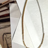 Flat lay of the Mixed Emotions Necklace which features mixed metal chain with gold and silver.