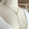 Front view of the Good Day Necklace which features a gold chain link lariat with a cross.