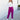 Full body front view of model wearing the Be Fearless Pants, that have magenta corduroy fabric, two front pockets, a paperbag waist with a tie, a zipper and button closure, and straight legs