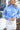 Front view of model wearing the You And Me Sweater, that has blue knit fabric with stitched details, a high neckline, and balloon sleeves with fitted wrists. Sweater is styled tucked up.