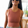 Front view of model wearing the On Repeat Brami In Rust, that features a rust coloring, stretchy-ribbed fabric, a cropped fit, and a high round neckline