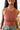 Close front view of model wearing the On Repeat Brami In Rust, that features a rust coloring, stretchy-ribbed fabric, a cropped fit, and a high round neckline