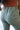 Close upper back view of model wearing the On The Go Jogger Pants, that have olive fabric, ruched detailing on the sides, two front pockets, two back pockets, an elastic waist band with a tie closure, and elastic ankles
