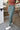 Front view of model wearing the On The Go Jogger Pants, that have olive fabric, ruched detailing on the sides, two front pockets, two back pockets, an elastic waist band with a tie closure, and elastic ankles