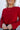 Close up view of model wearing the Always A Hit Sweater which features red ribbed knit fabric, a cropped waist, a round neckline and balloon sleeves with cuffed wrists.