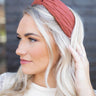 Side view of model wearing the Sadie Headband in Rust, which features a structured band with a satin lining and a quilted exterior with a top twist.