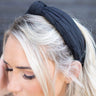 Top view of model wearing the Sadie Headband in Black, that features a structured band with a satin lining and a quilted exterior with a top twist.