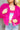 Close up view of model wearing the Make A Statement Jacket which features hot pink soft shag fabric, hidden button closures, two front pockets, cropped waist and long balloon sleeves. The jacket is open. 