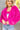 Close up view of model wearing the Make A Statement Jacket which features hot pink soft shag fabric, hidden button closures, two front pockets, cropped waist and long balloon sleeves. The jacket is open. 