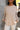 Close up view of model wearing the Fireside Feels Sweater in Beige which features beige fabric, a high-low hemline, one pocket on the left chest, a round neckline, and long sleeves.