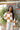 Close up view of model wearing the Check This Out Sweater which features white and camel knit fabric with a checkered pattern, a round neckline, a cropped waist and long sleeves.