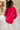 Back view of model wearing the Up All Night Satin Top which features hot pink satin fabric, monochromatic button up, collared neckline, high-low hem and long sleeves with button closure cuffs.