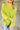 Close up view of model wearing the Ready Or Not Sweater In Lime which features lime knit fabric, slits on the hem, a round neckline, drop shoulders and balloon long sleeves with fitted wrists.