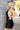 Side view of model wearing the Skylar Satin Dress in Black which features black satin fabric, halter neckline with a tie, ruching on the sides, back zipper with hook closures and lining.
