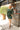 Full body view of model wearing the Unforgettable Dress which features green sheen fabric, smalls slits on each side of the hem, ruching on the sides, round neckline, lining and long sleeves.