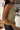 Side view of model wearing the Moving Forward Tank which features green ribbed knit fabric, cropped waist and v neckline.