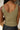 Close up back view of model wearing the Moving Forward Tank which features green ribbed knit fabric, cropped waist and v neckline.