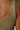 Close up back view of model wearing the Moving Forward Tank which features green ribbed knit fabric, cropped waist and v neckline.