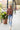 Full body view of model wearing the Just Relax Top In Marsala features brown fabric, a round neckline, and balloon long sleeves.