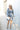 Full body front view of model wearing the Star Light Dress features grey sheen fabric, a square neckline, smocked back detailing, and balloon long sleeves with elastic wrists.