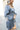 Side view of model wearing the Star Light Dress features grey sheen fabric, a square neckline, smocked back detailing, and balloon long sleeves with elastic wrists.