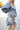 Side view of model wearing the Star Light Dress features grey sheen fabric, a square neckline, smocked back detailing, and balloon long sleeves with elastic wrists.