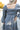 Back view of model wearing the Star Light Dress features grey sheen fabric, a square neckline, smocked back detailing, and balloon long sleeves with elastic wrists.