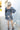 Full body back view of model wearing the Star Light Dress features grey sheen fabric, a square neckline, smocked back detailing, and balloon long sleeves with elastic wrists.