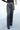 Front view of model wearing the Wish Upon A Star Pants, that have black fabric with metallic silver threads, an elastic band, and flared legs.